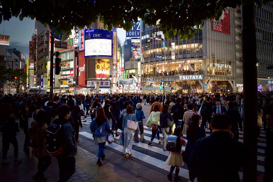 Tokyo downtown street covered with people that are walking in all directions.