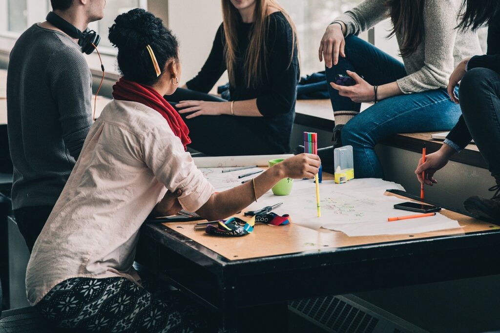  A group of young adults collaborating on a project around a table.