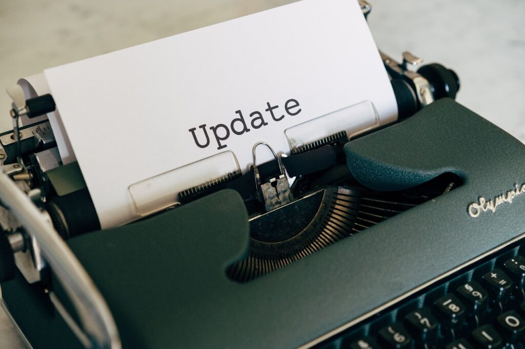 A close-up of a typewriter with a piece of paper showing the word "Update" typed on it.