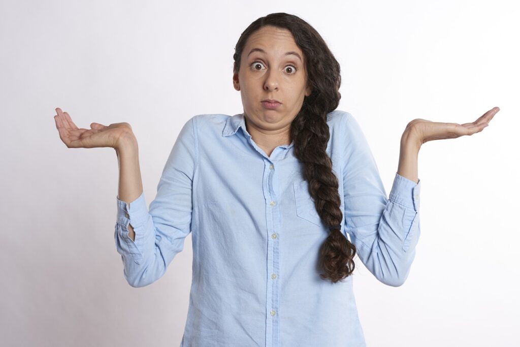 A woman shrugging with a puzzled expression, reflecting confusion about Japanese particles.