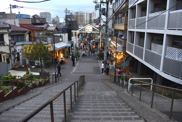 Bustling shopping street in Nishi Nippori, Tokyo, lined with shops and local eateries.