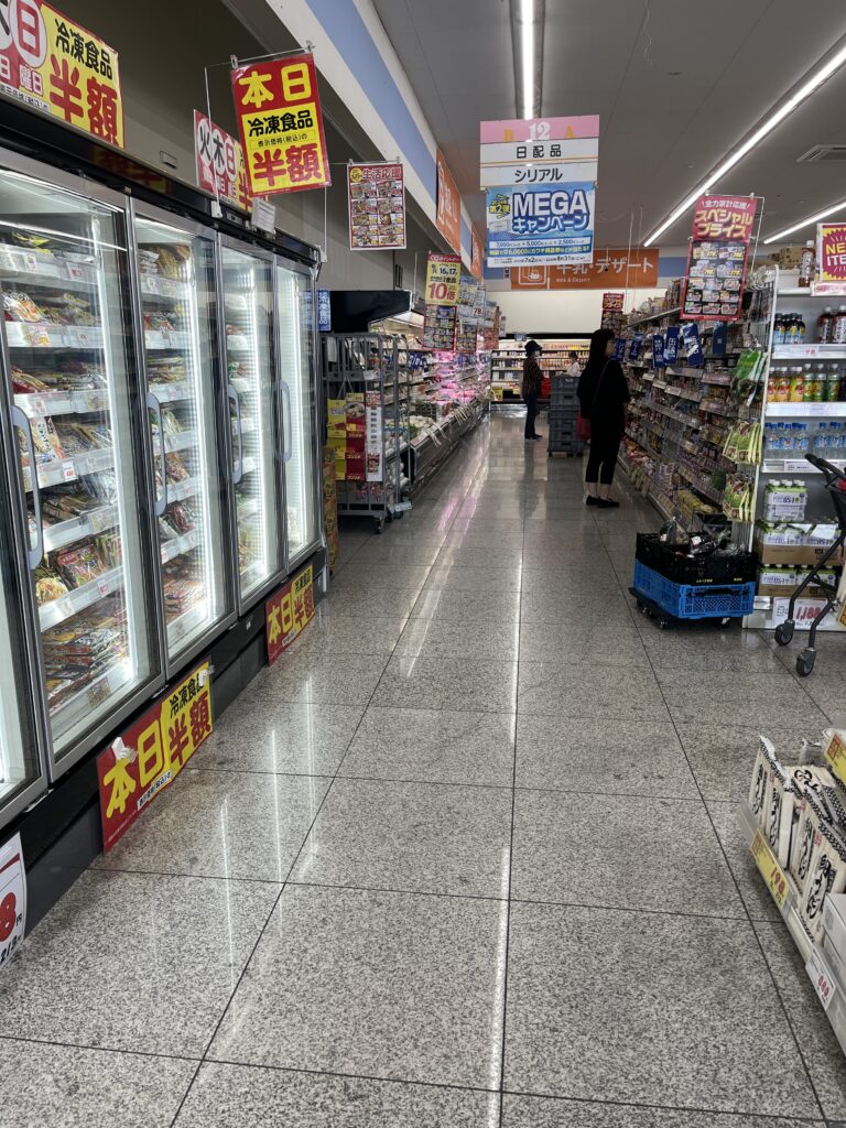 Japanese supermarket aisle with rice, seaweed, and seasonings on neatly organized shelves.