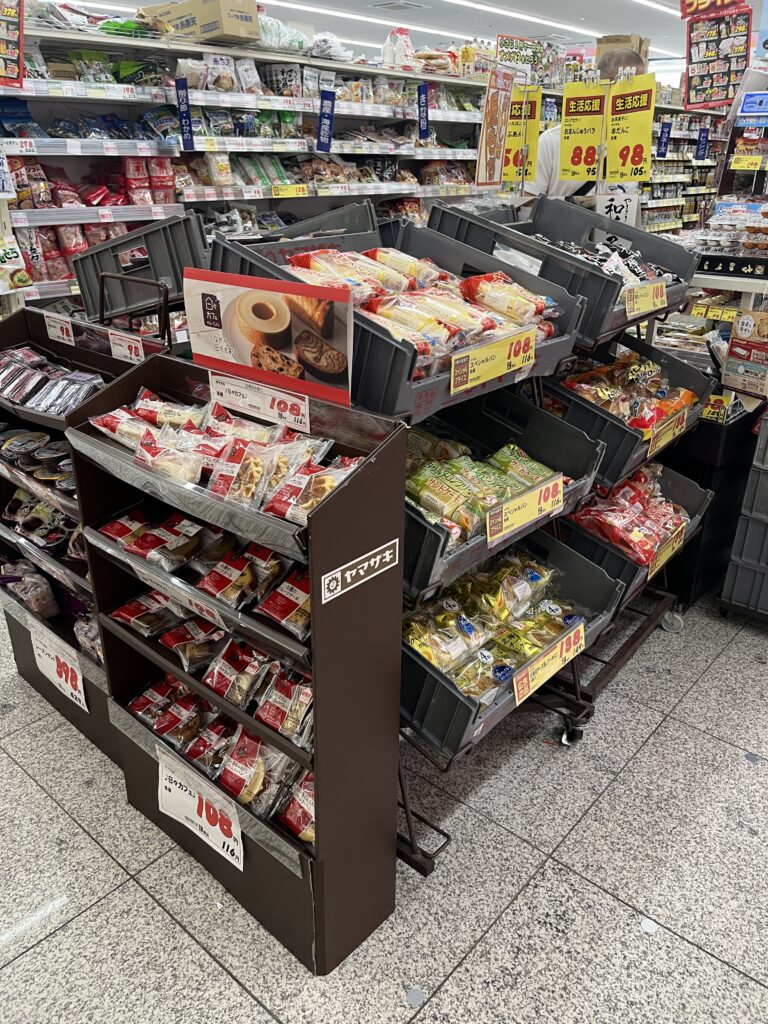 Japanese supermarket snack display featuring rice crackers and other traditional Japanese snacks.