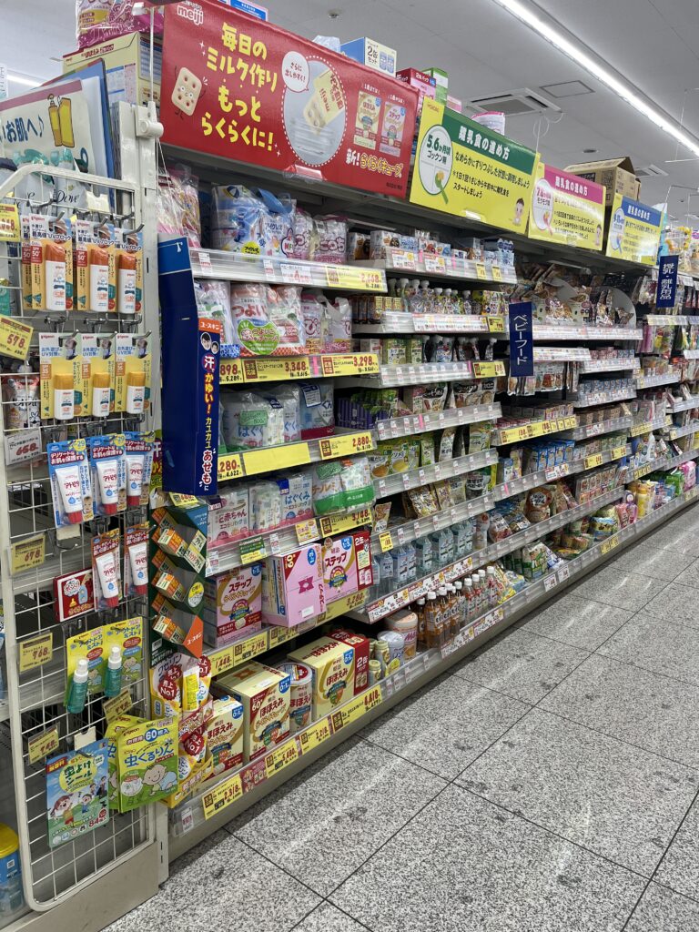 Japanese supermarket aisle filled with baby products, including milk formula, diapers, and baby food.