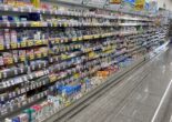 Japanese supermarket aisle with a variety of health and hygiene products, including ointments, skincare, and personal care items.