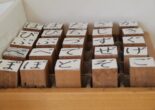 Wooden stamps with hiragana characters neatly arranged in a box.