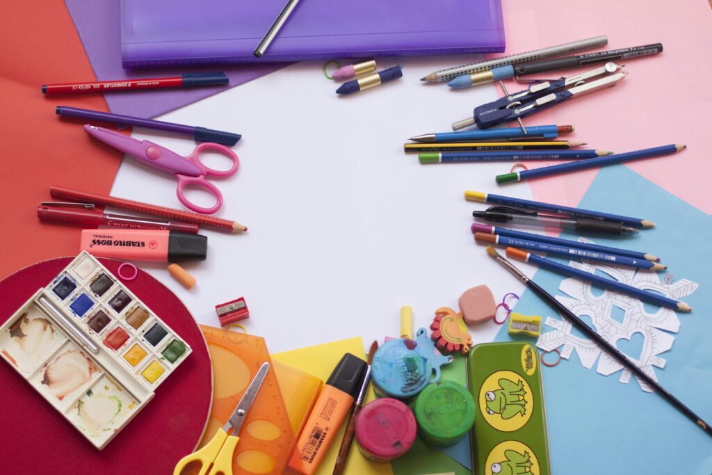 A variety of colorful art supplies, including pencils, paint, scissors, and paper, spread out on a table in Japan, ready for use.