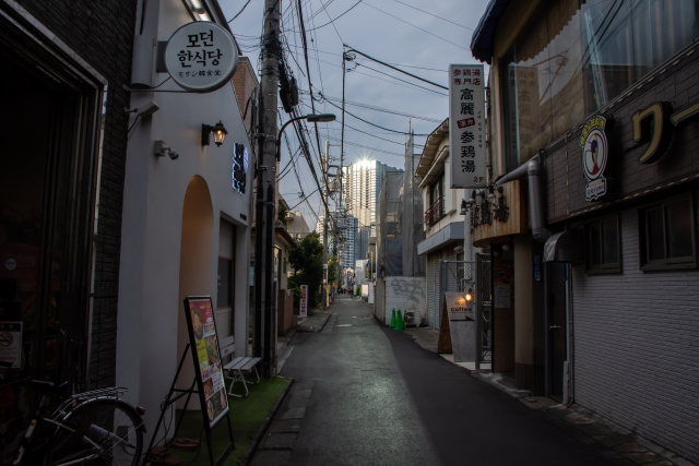 A narrow back street in Shin-Okubo with Korean signs and small eateries along the road.