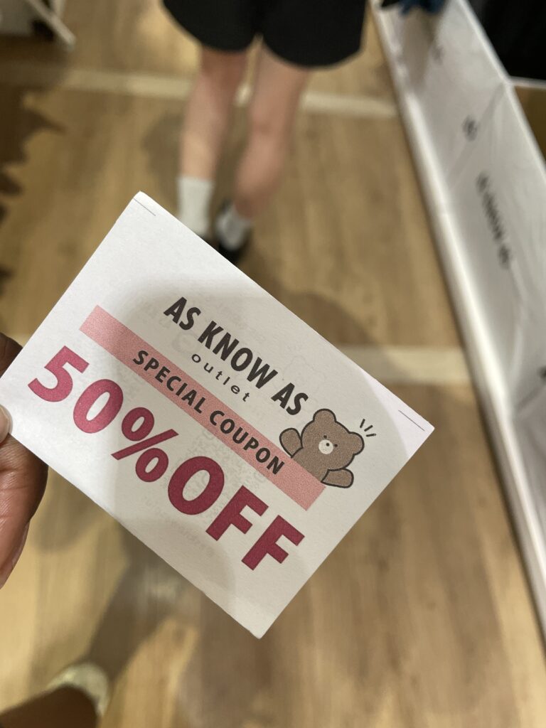 A 50% off special coupon from As Know As Outlet, featuring a cute bear illustration. 