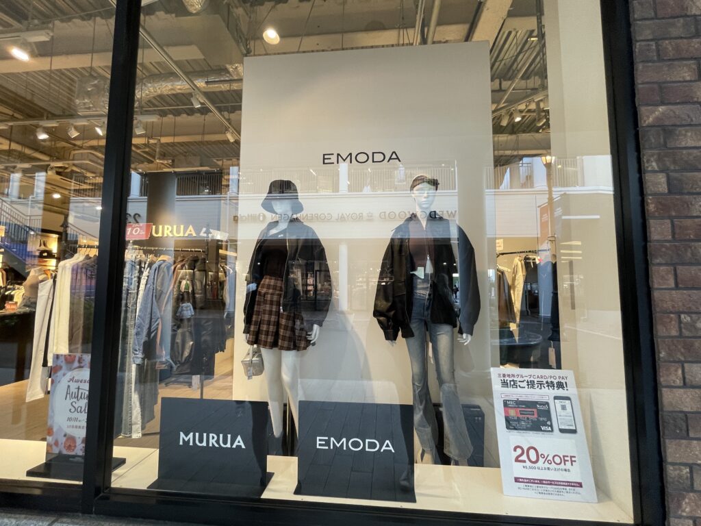 A window display at the Emoda store, featuring stylish mannequins wearing autumn fashion.