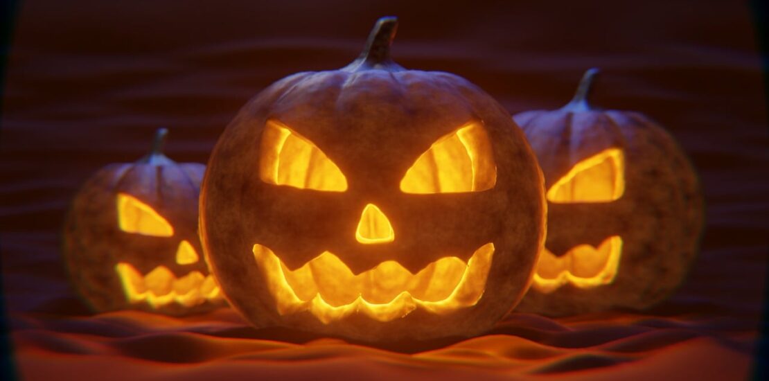 Three spooky Jack-o'-lanterns glowing eerily in the dark, each with a menacing grin.