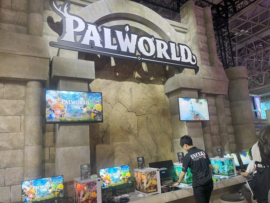 Staff preparing demo stations at the Palworld booth during TGS 2024.