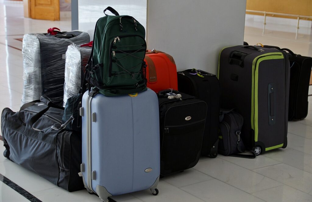 A collection of suitcases and a green backpack at an airport or station, ready for travel.