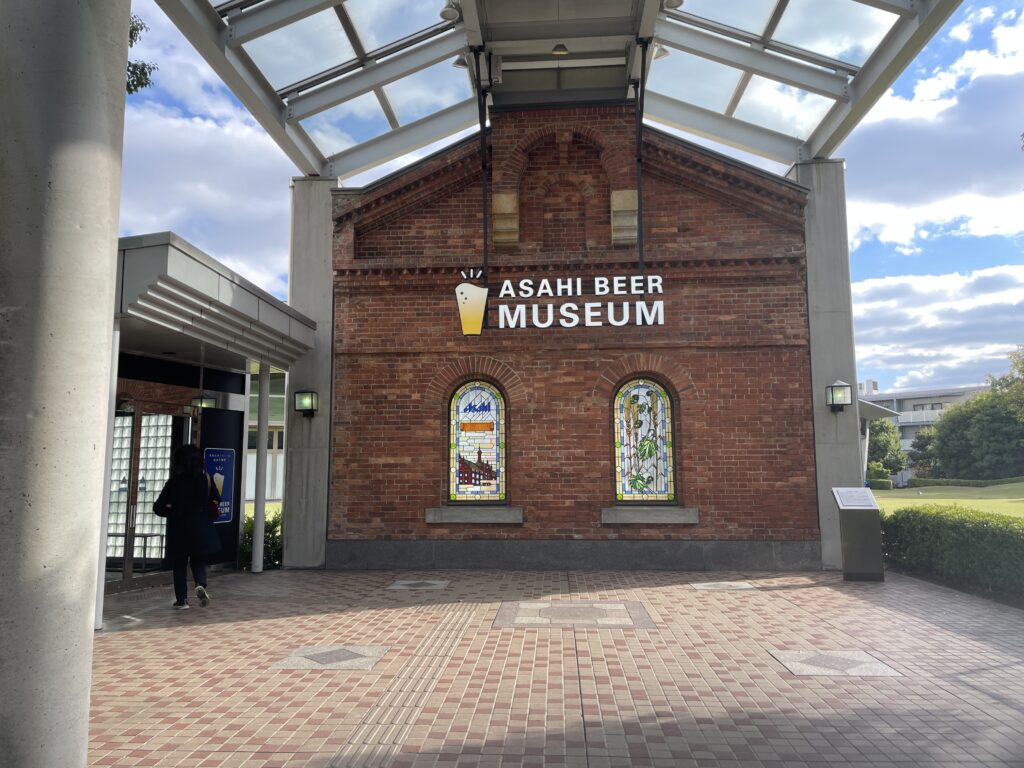 Exterior view of the Asahi Beer Museum, featuring a brick building with colorful stained glass windows and the museum's logo.