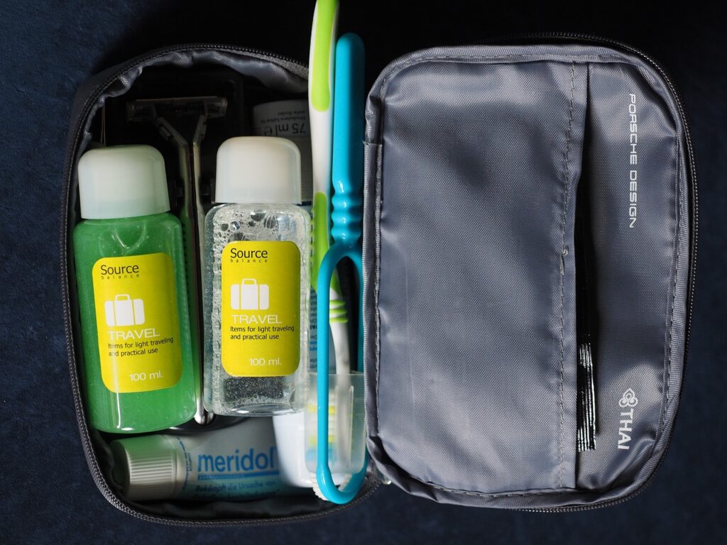 Travel toiletry kit containing shampoo, toothpaste, toothbrush, and other small essentials.