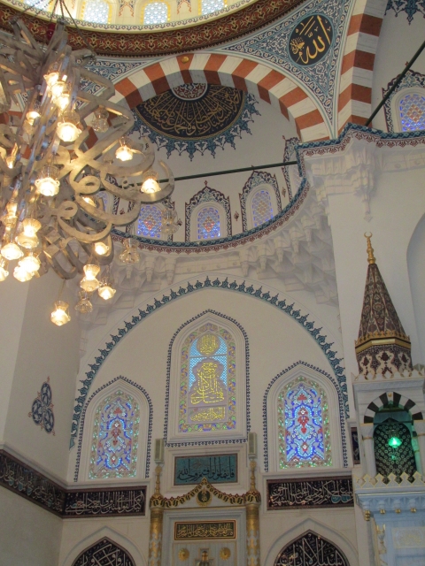 Interior view of Tokyo Camii Mosque with intricate Islamic architecture and colorful stained glass.