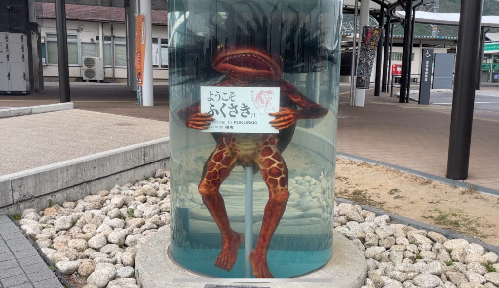 A life-sized Kappa statue in a display case welcoming visitors to Fukusaki City.