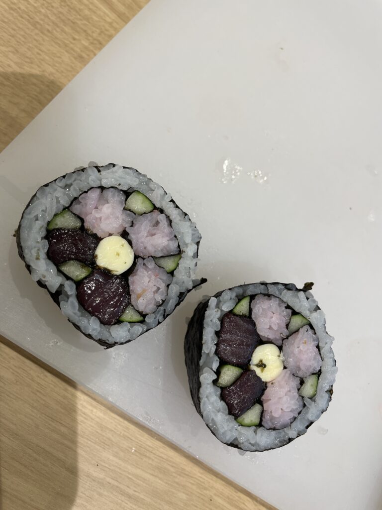 Two decorative sushi rolls resembling flower designs, crafted during a sushi roll-making class at Wakayama’s roadside station.