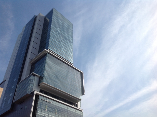 Shibuya Sky building towering against a bright blue sky.