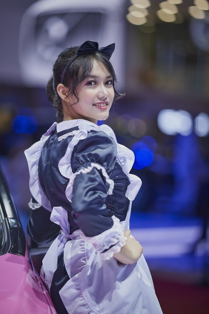 Smiling Japanese maid posing confidently in uniform, representing the welcoming and respectful ambiance of Japanese maid cafes.