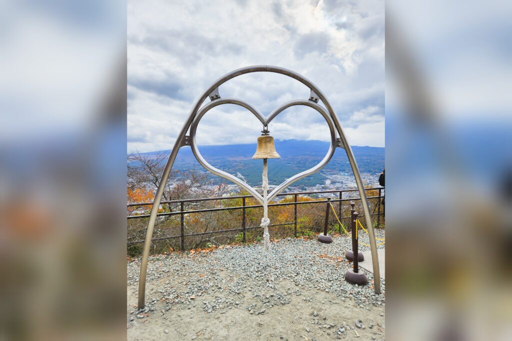 The Bell of Tenjo framed in a heart-shaped arch in the background.