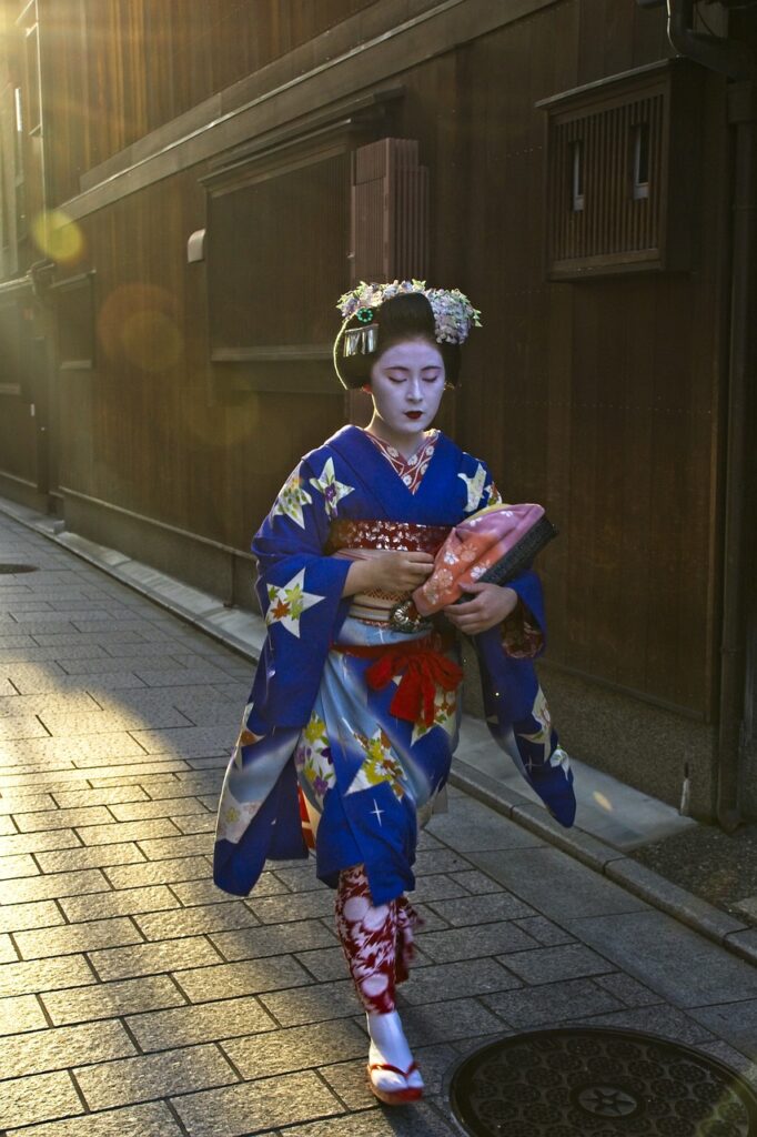 A maiko walking along a traditional Kyoto street, wearing a vibrant blue kimono.