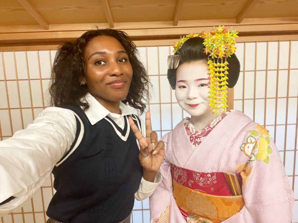 A visitor posing with a maiko in traditional attire at a Kyoto cultural experience.