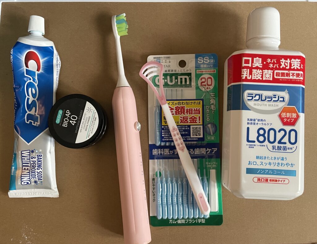 A pink electric toothbrush with a charger, lying on a flat surface.