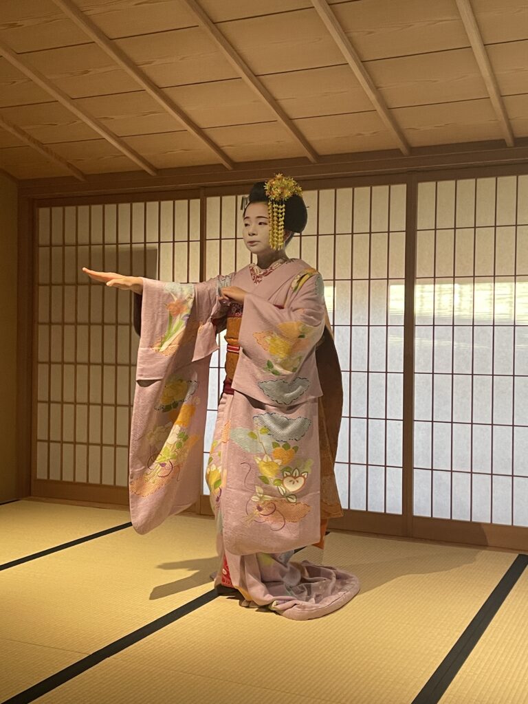 Maiko performing a graceful traditional dance inside a Kyoto geiko house.