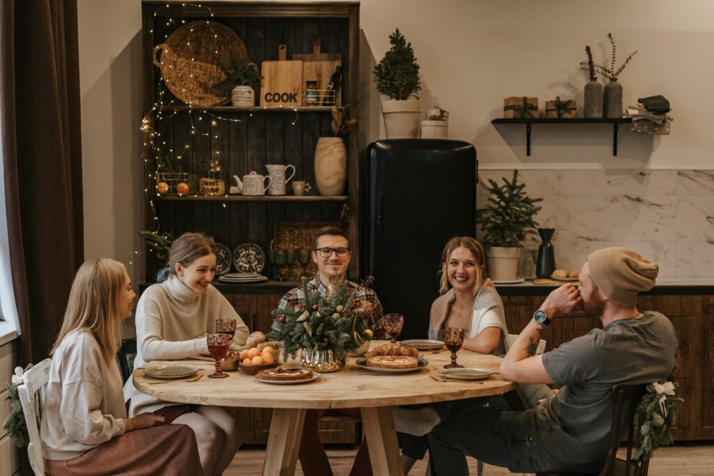 A group of friends sharing a festive meal around a decorated table.