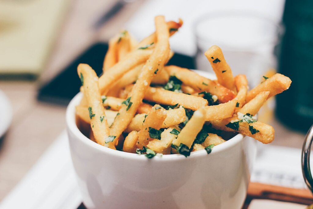 A cup of crispy golden fries sprinkled with herbs, served at Freshness Burger in Umeda.