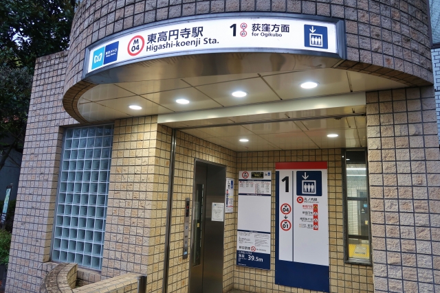 A typical subway entrance in the nearby suburbs of Tokyo, showcasing a tiled exterior and an illuminated station sign.