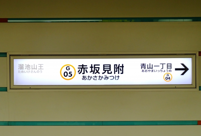 A view of the Fukutoshin Line station platform in Tokyo, displaying modern subway signage and directional indicators.