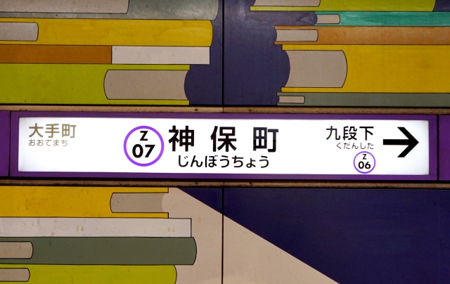 A view of the Fukutoshin Line station platform in Tokyo, displaying modern subway signage and directional indicators.