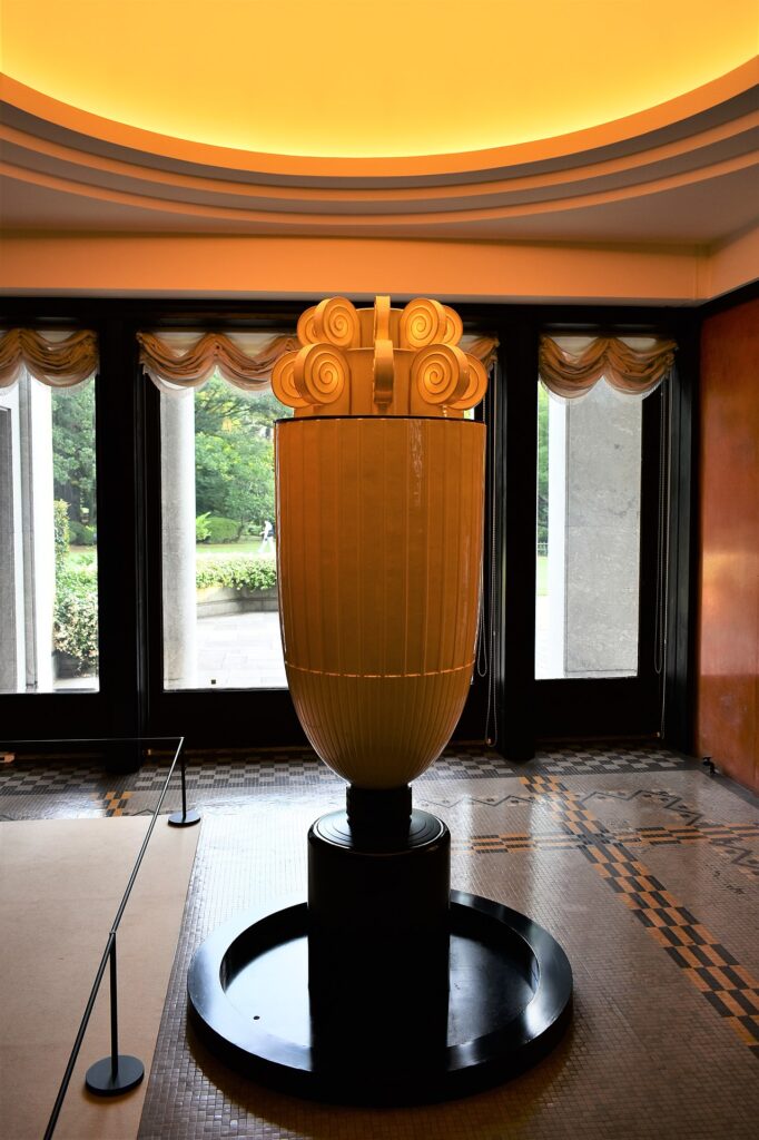 A luxurious dining room in the Tokyo Teien Art Museum with a white tablecloth, ornate glassware, and gold-accented chairs. Ebisu