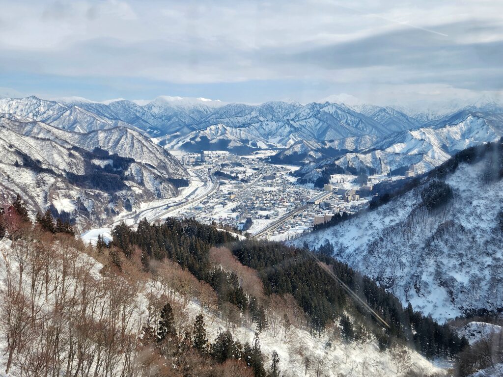 A stunning bird’s-eye view of snow-covered Yuzawa Town surrounded by mountains.