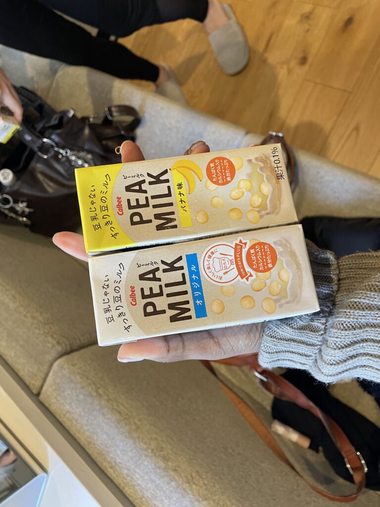 Two cartons of Calbee Pea Milk, one original flavor and one banana flavor, held in someone's hand.