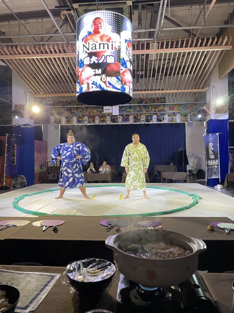  Two sumo wrestlers performing the traditional foot-stamping ritual inside the sumo ring.