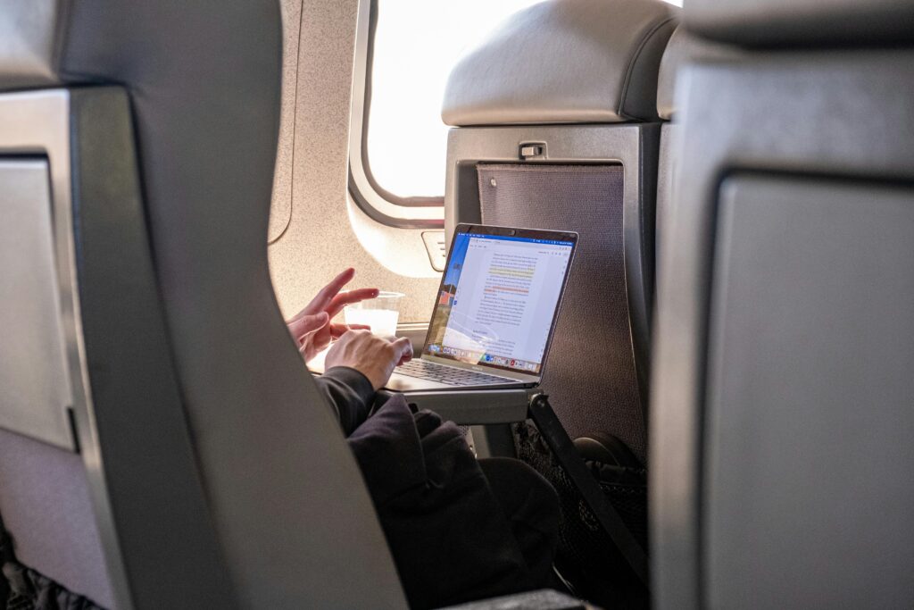 A person working on a laptop while traveling on a train.