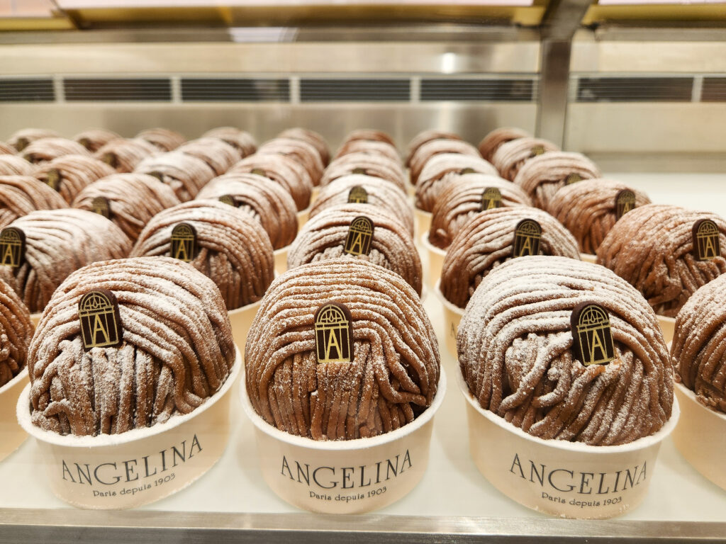 Rows of Angelina’s famous Mont Blanc pastries, dusted with powdered sugar and topped with the iconic Angelina logo.