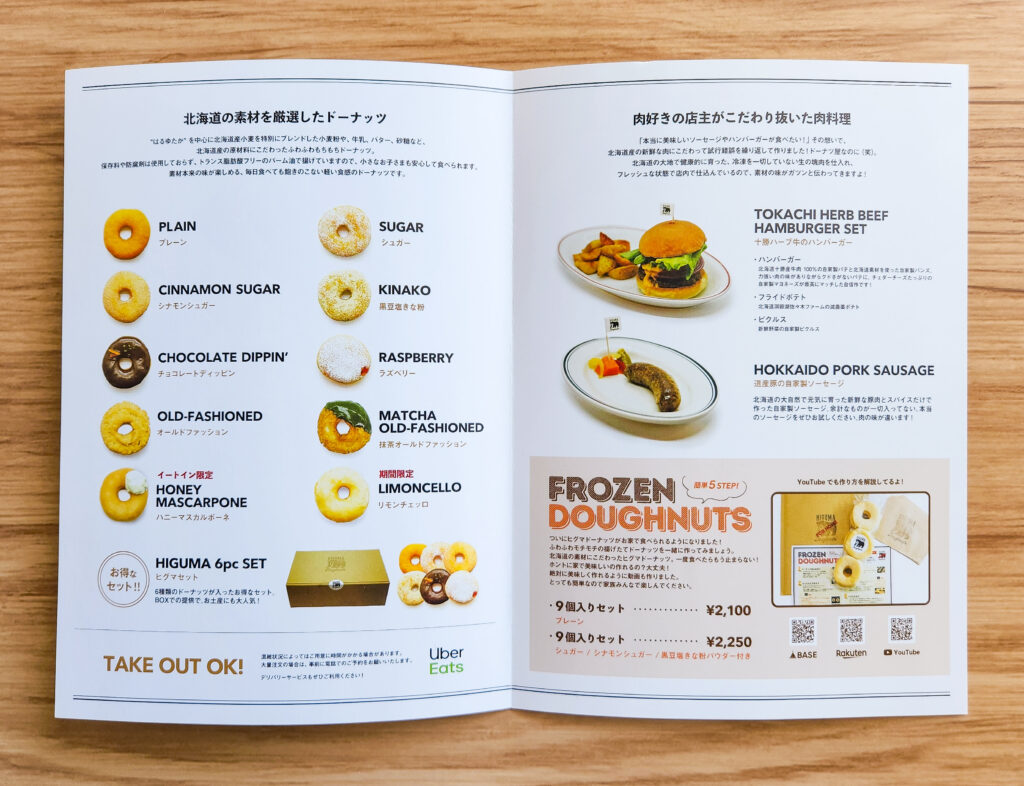 A menu showcasing Higuma Doughnuts’ selection, including plain, matcha, kinako, and chocolate-dipped flavors, alongside their frozen doughnuts and meat dishes.