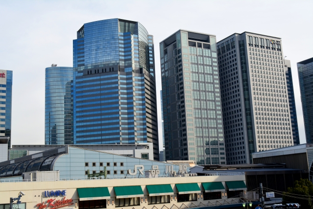 A cluster of towering glass skyscrapers reflecting the skyline above JR Station, highlighting its status as a major business hub.