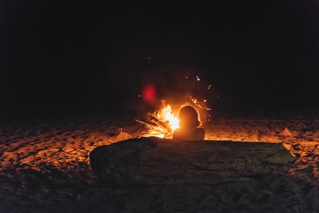 Toasted marshmallow on a skewer over a camping gas flame.