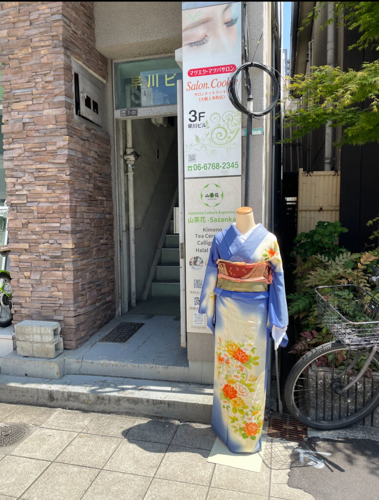 Entrance to traditional Sazanka Osaka with mannequin in blue kimono.