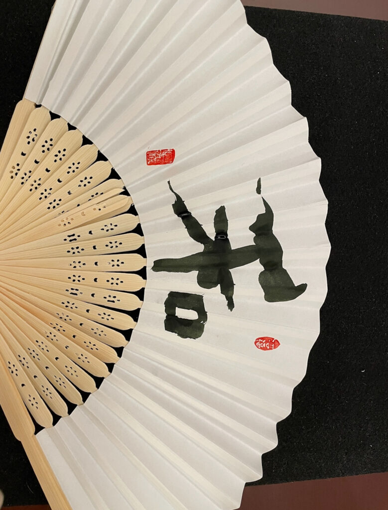 Hand-painted folding fan with traditional kanji at Sazanka Osaka,