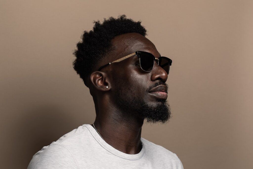 Man with a short afro and fade hairstyle, showcasing well-maintained natural hair.