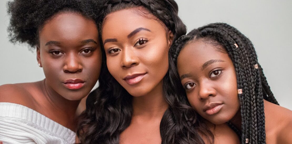 Three women with afro, wavy, and braided hairstyles, each reflecting different hair care needs.
