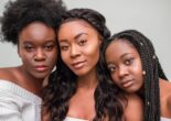 Three women with afro, wavy, and braided hairstyles, each reflecting different hair care needs.