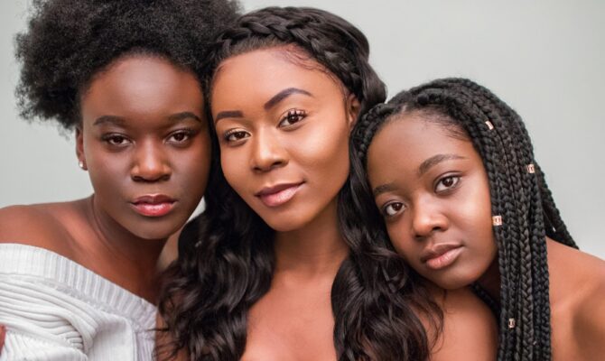Three women with afro, wavy, and braided hairstyles, each reflecting different hair care needs.