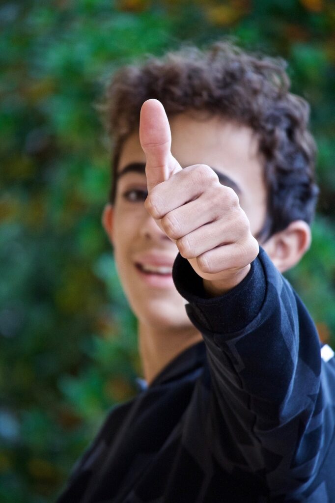 Smiling person giving a thumbs-up gesture.